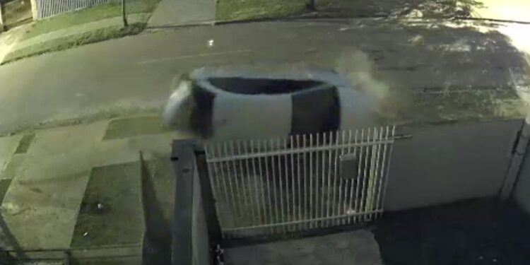 Dupla em fuga colide em carro estacionado, bate em portão e capota, veja o vídeo