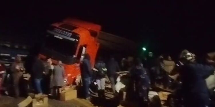 Carreta carregada com carne é atingida por trem e população saqueia a carga