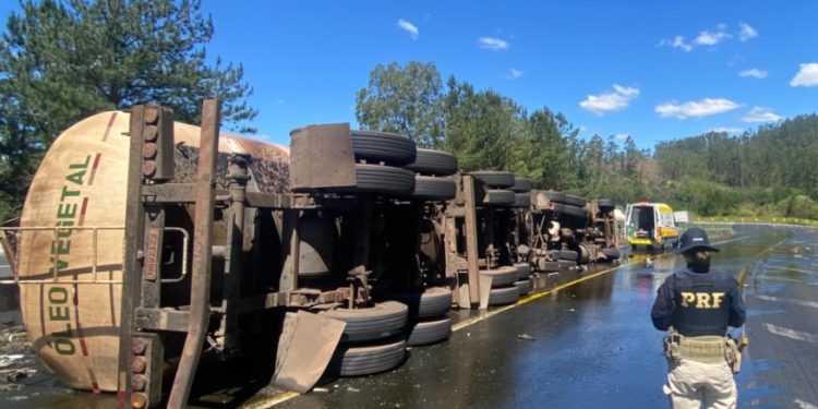 Carreta carregada com óleo vegetal tomba e deixa motorista preso às ferragens na BR-376