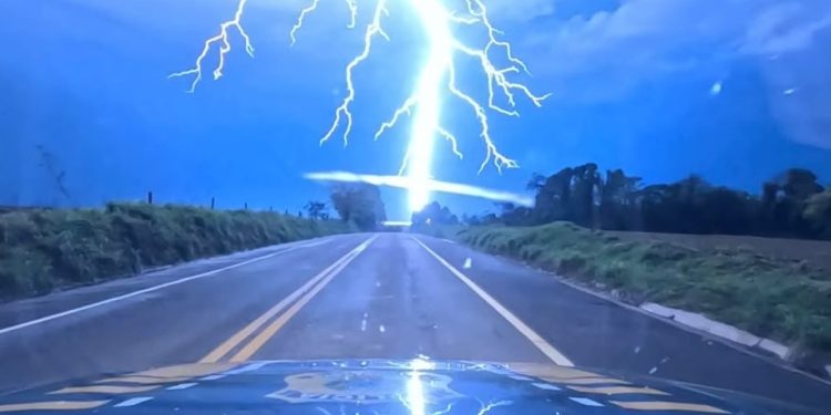 Câmera em viatura da PRF registra raio atingindo margens da BR-272 durante tempestade no Paraná